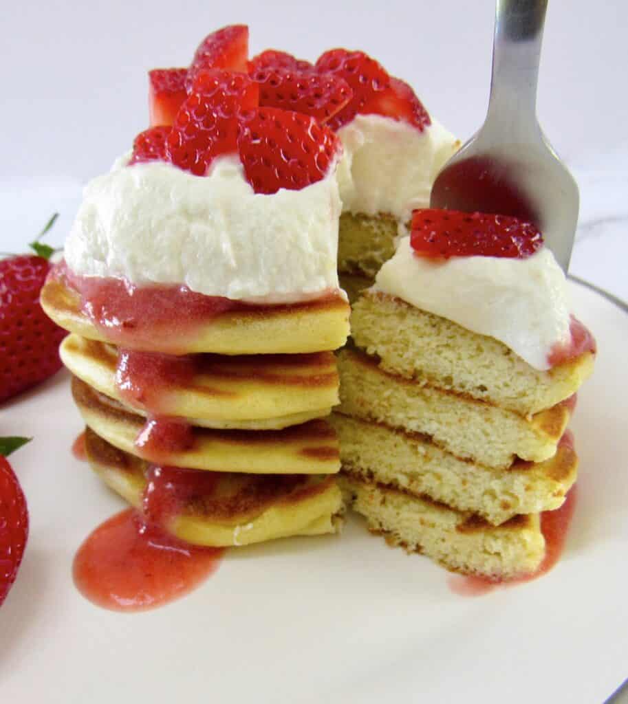 stack of pancakes cut with fork holding some