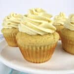 closeup of vanilla cupcakes on white cake stand