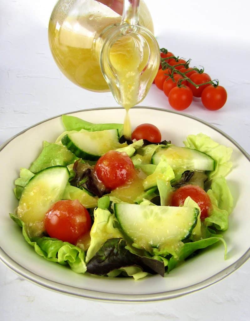 salad with apricot dressing being poured on top