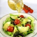 salad with apricot dressing being poured on top