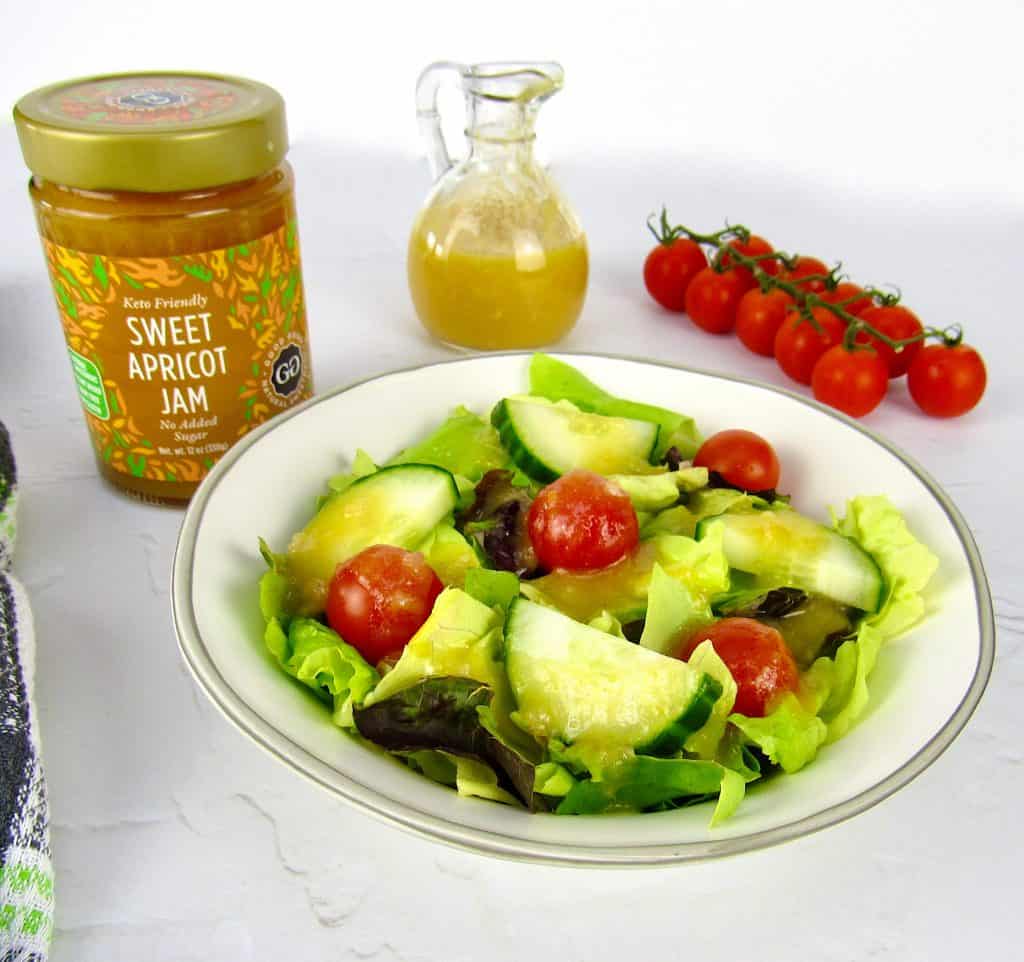 salad with apricot dressing on top and jar of jam in background