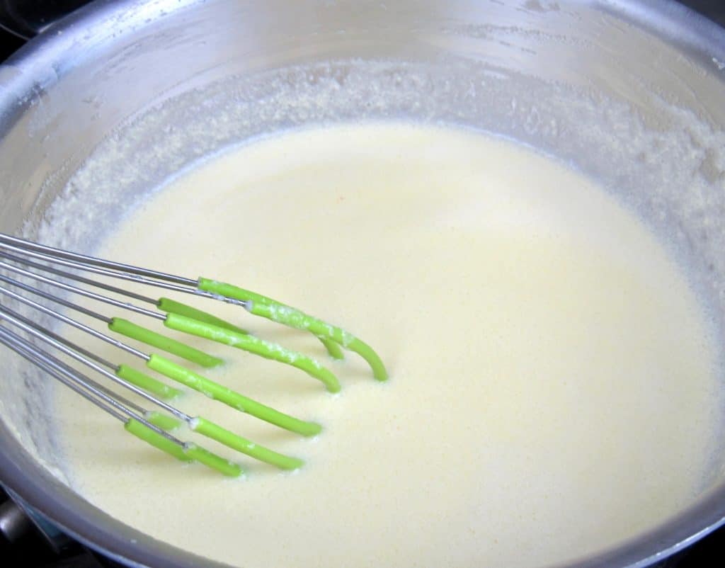 heavy cream in pot with whisk