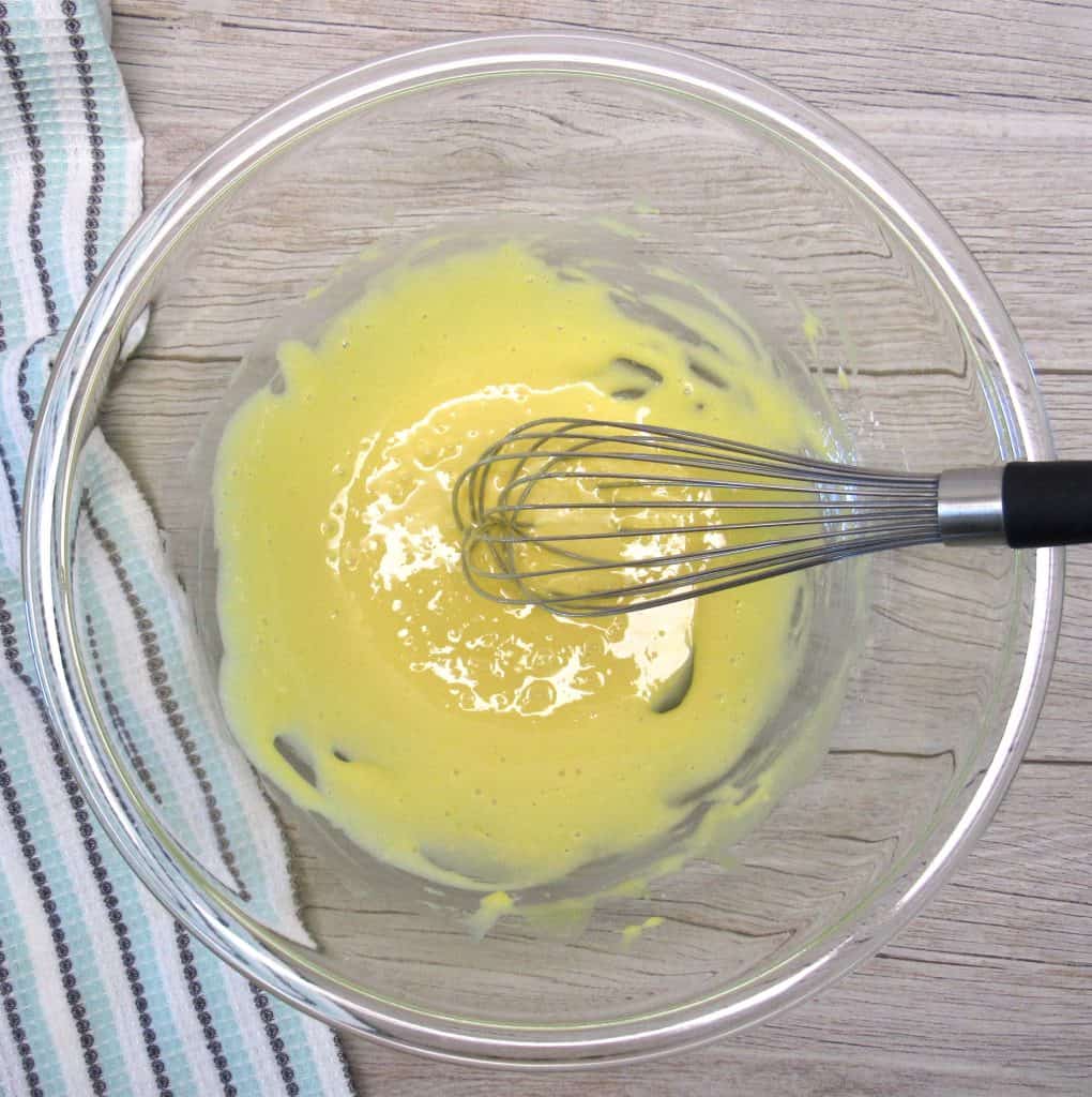 raw eggs beaten with sugar in bowl with whisk