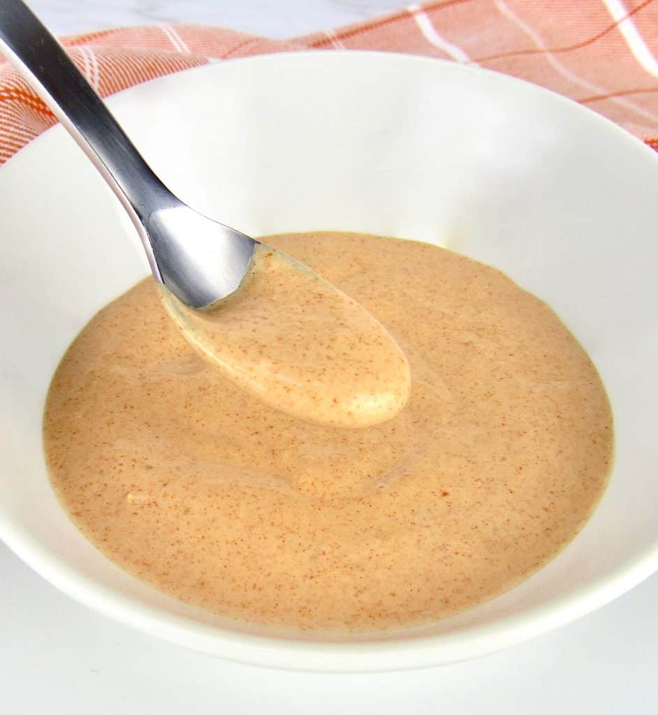 bowl of zesty dipping sauce with spoon holding up some