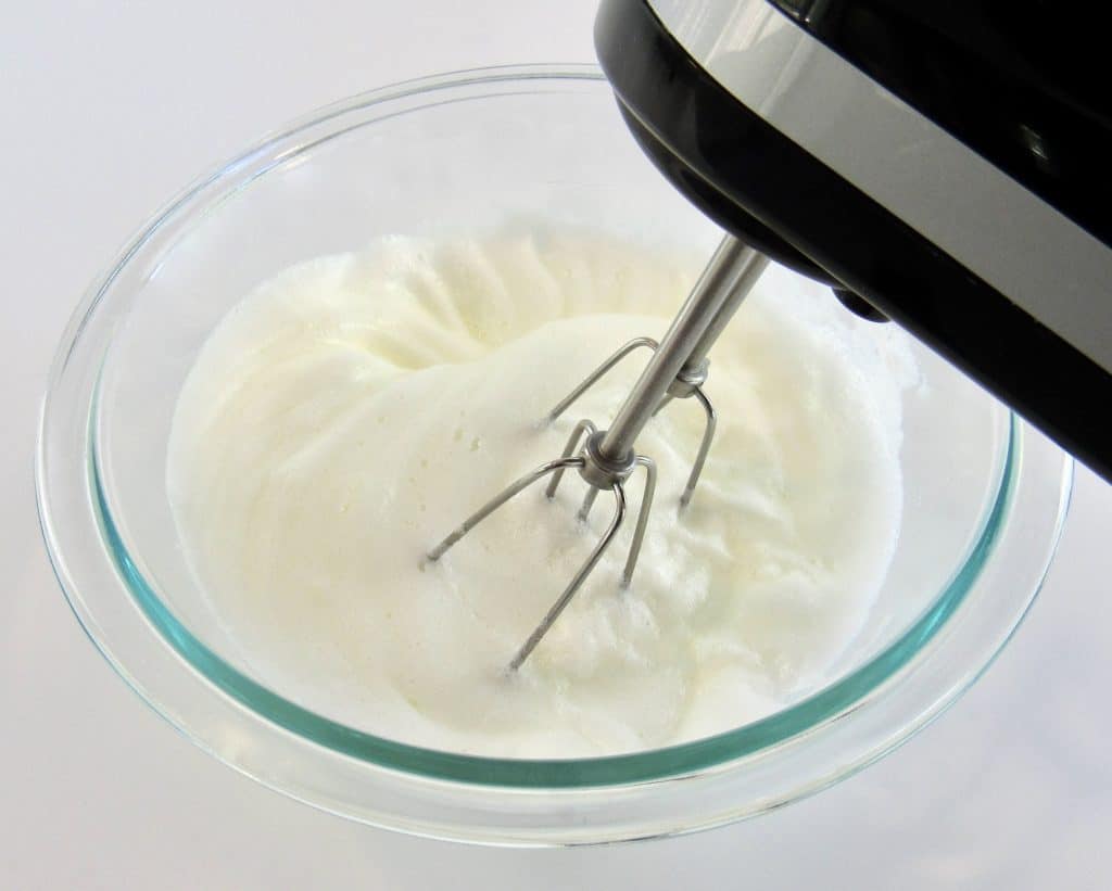 whipped egg whites in glass bowl