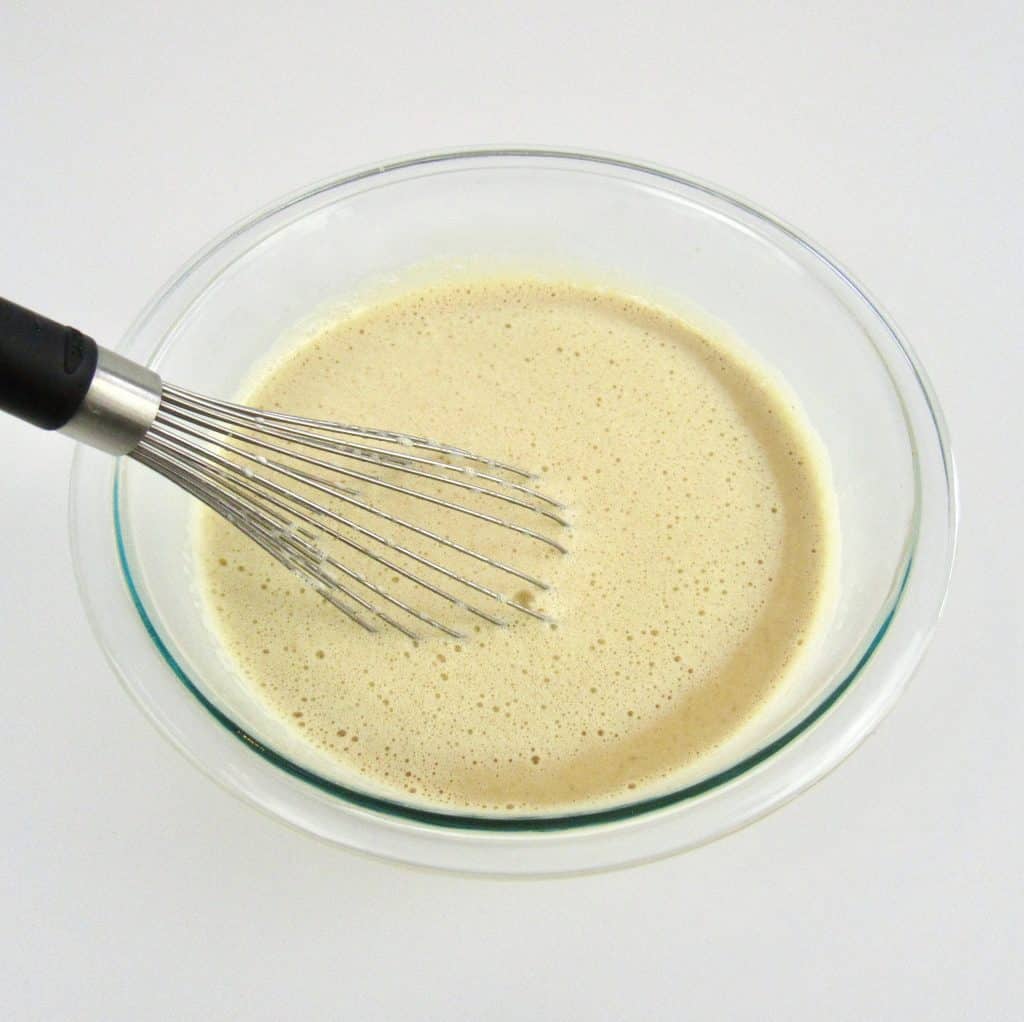 creme brûlée wet ingredients in glass bowl with whisk mixed