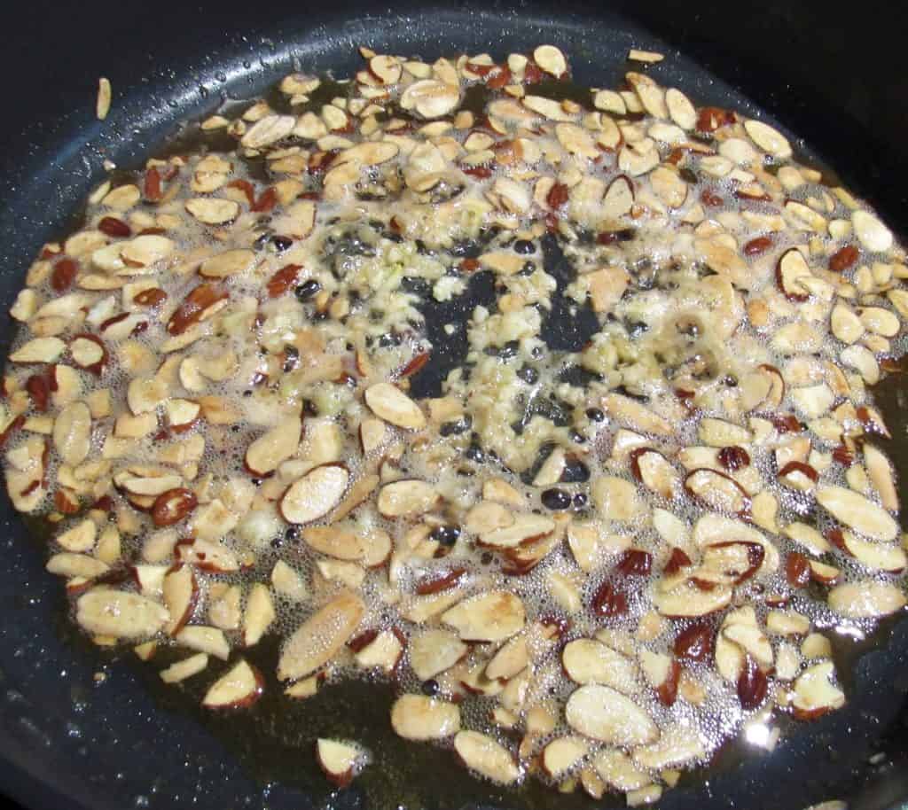 almonds toasting in skillet with butter and garlic