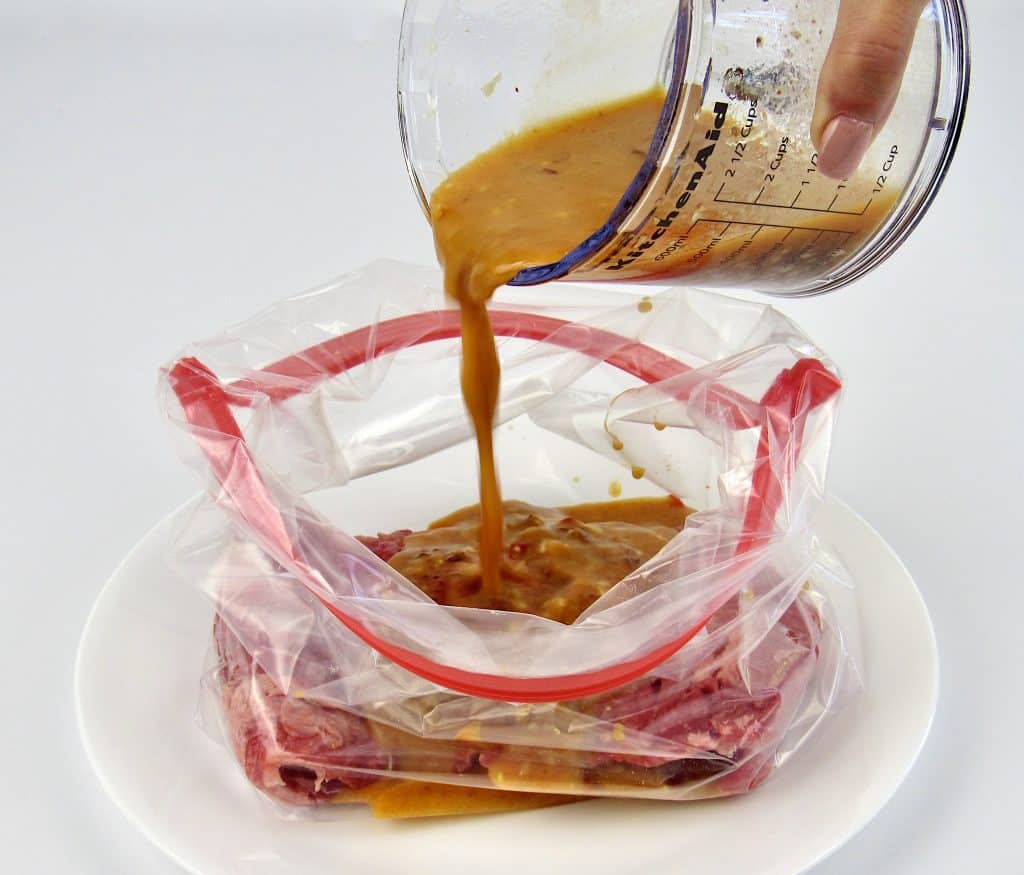 chipotle lime marinade being poured over steak in bag