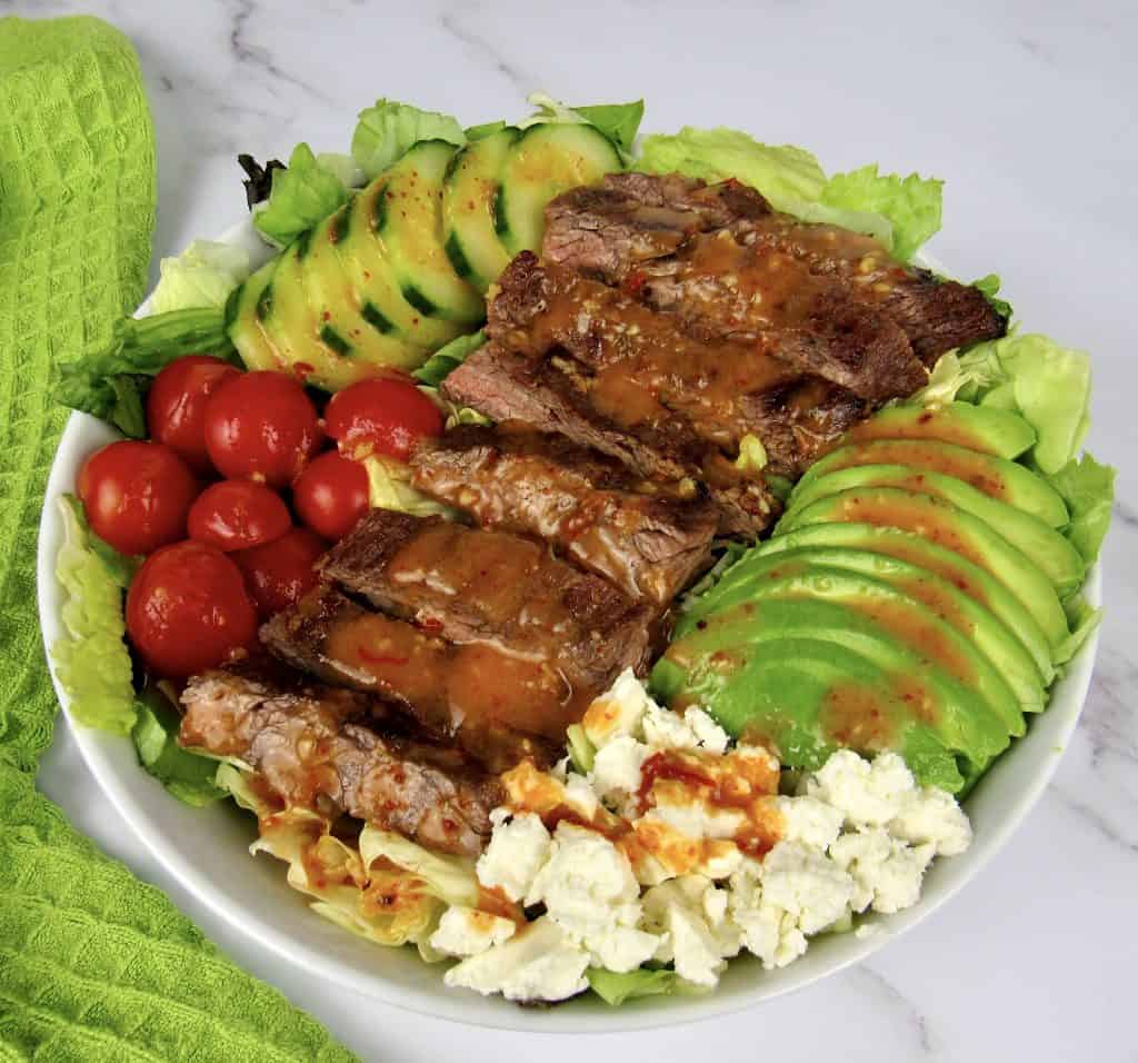 closeup overhead view of grilled steak salad with dressing on top