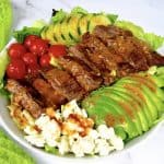 overhead view of grilled steak salad with dressing on top