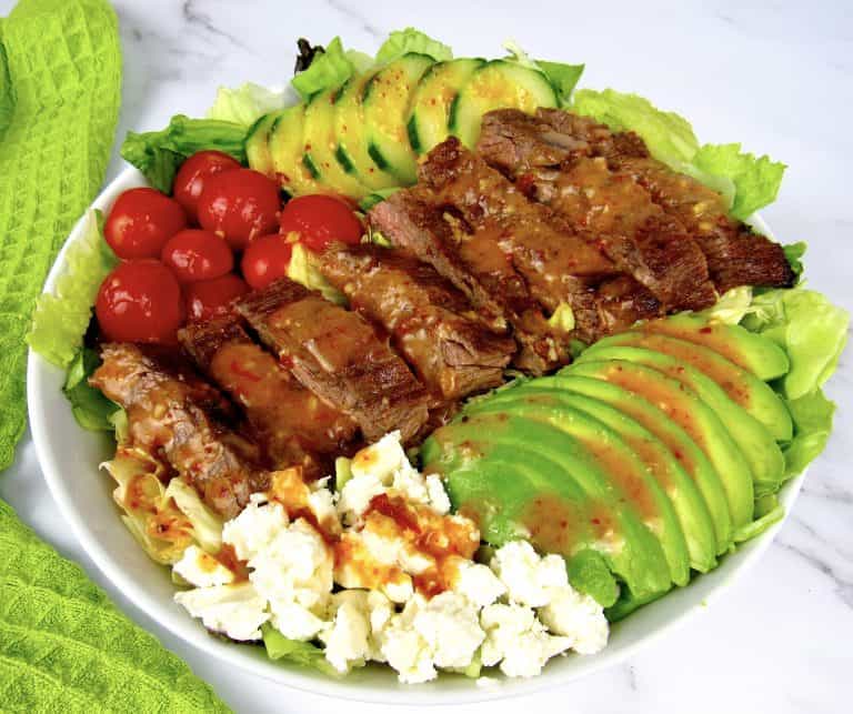 overhead view of grilled steak salad with dressing on top