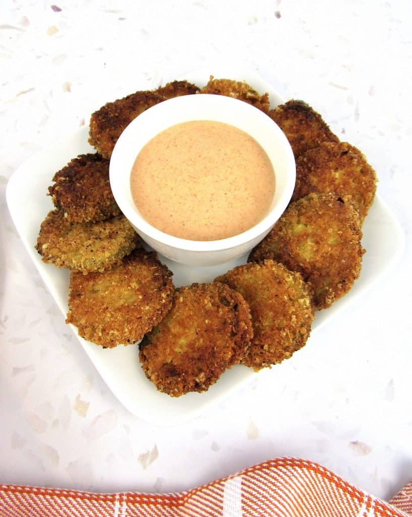 overhead view of fried pickles on plate with dipping sauce in bowl