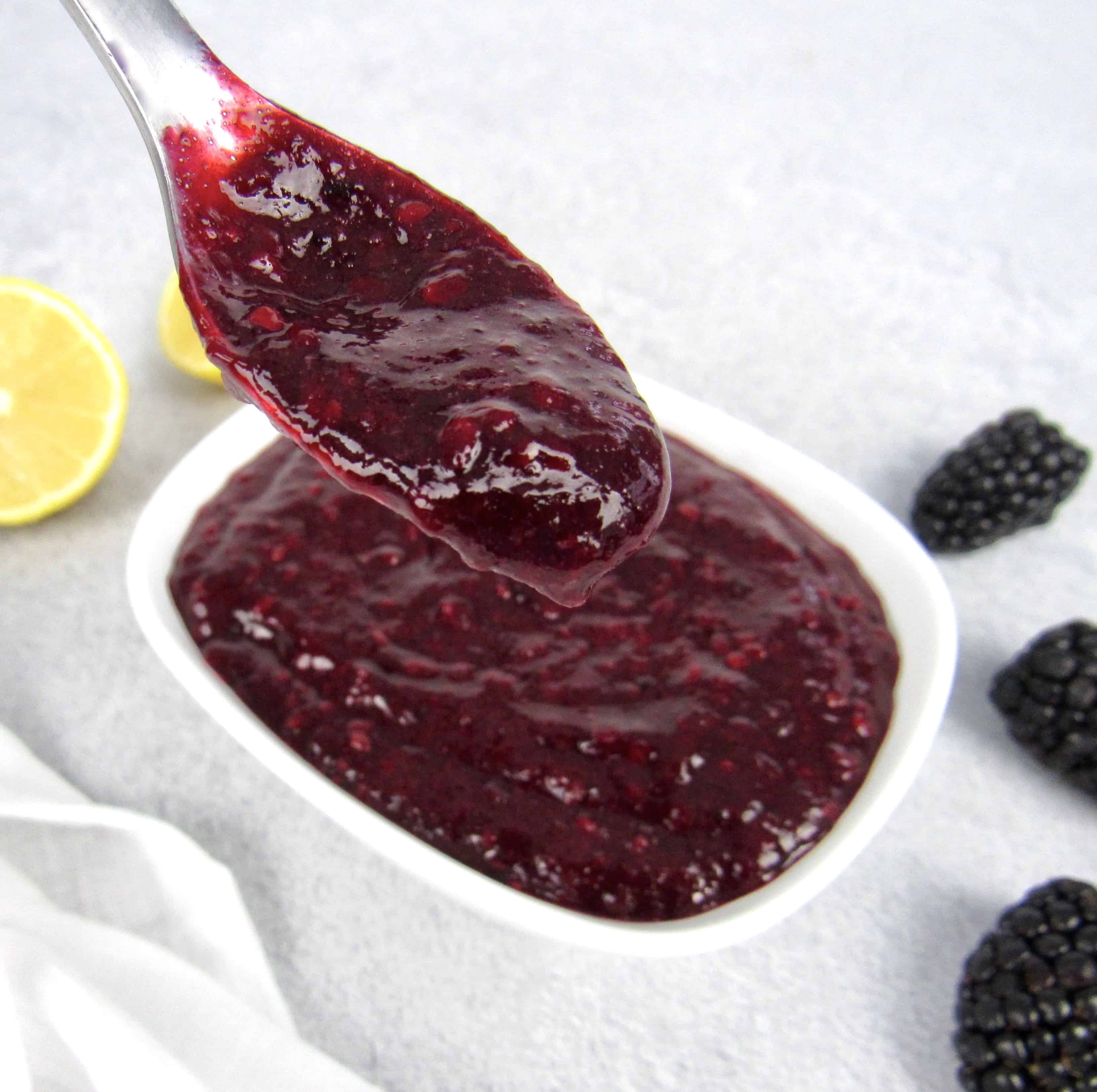 blackberry jam in spoon being held up