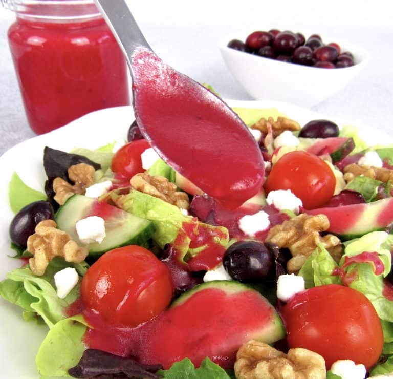 cranberry dressing in spoon held over salad