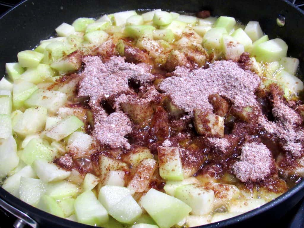 chayote squash cooking in skillet with brown sugar on top