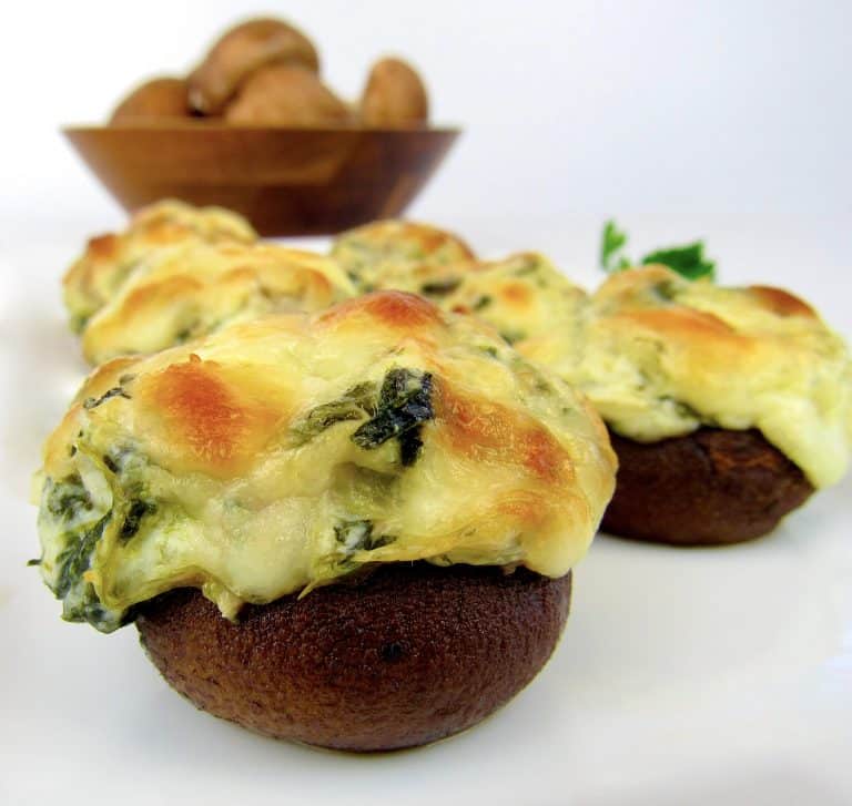 Spinach Artichoke Stuffed Mushrooms with mushrooms in background