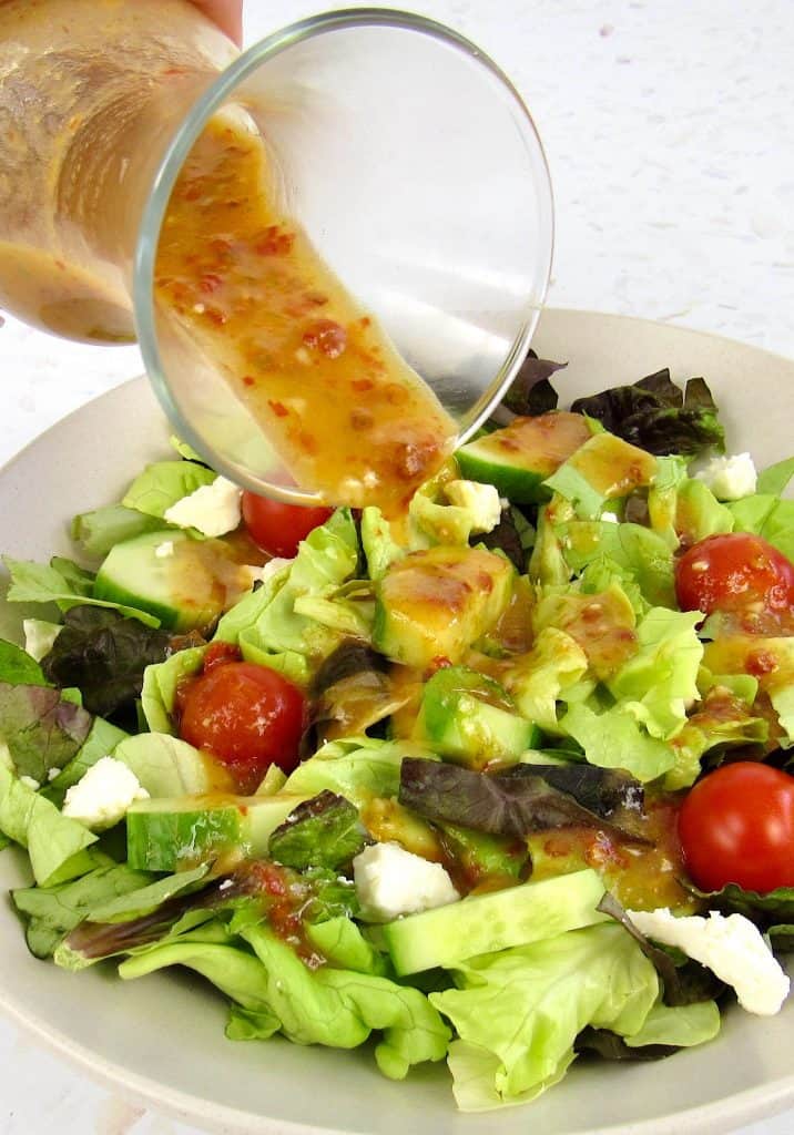 Vinaigrette being poured over salad