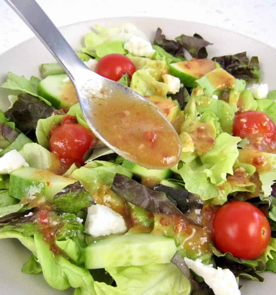 Vinaigrette being spooned over salad