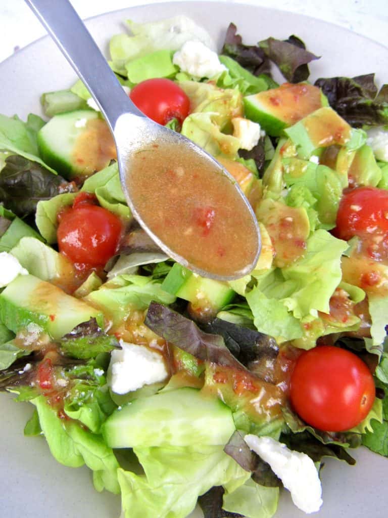 Vinaigrette being spooned over salad