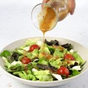 Vinaigrette being poured over salad