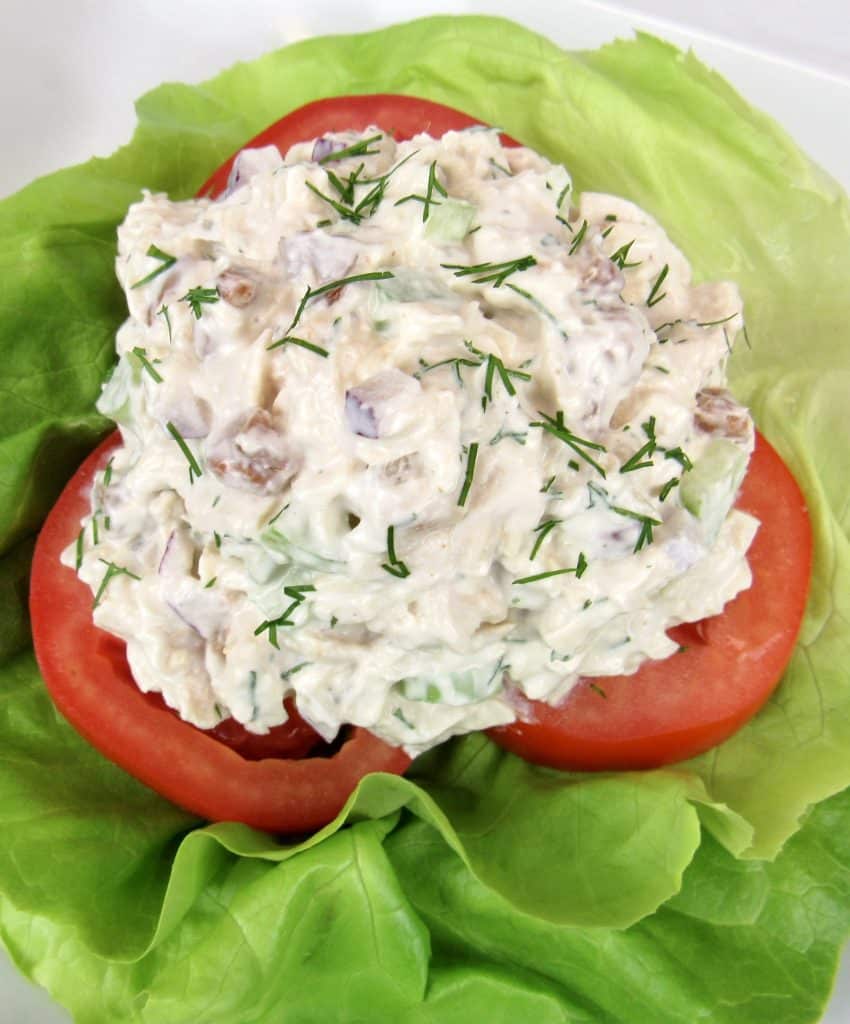 scoop of chicken salad on tomatoes and lettuce