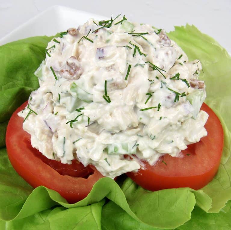 scoop of chicken salad on tomatoes and lettuce