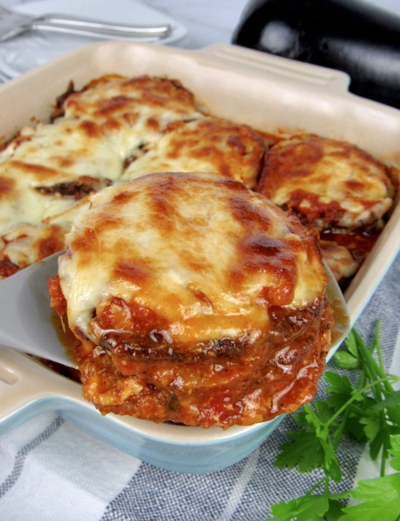 eggplant parmesan being spooned out of a casserole