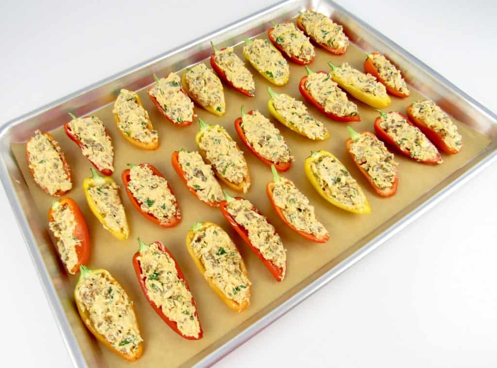 chorizo stuffed raw mini peppers on baking sheet