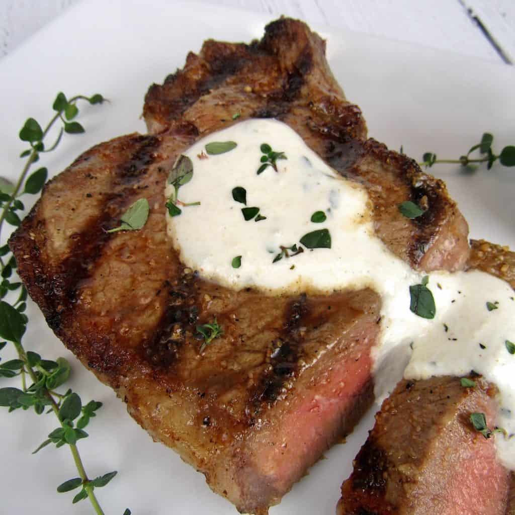 closeup of cut steak with Creamy Horseradish Sauce over the top
