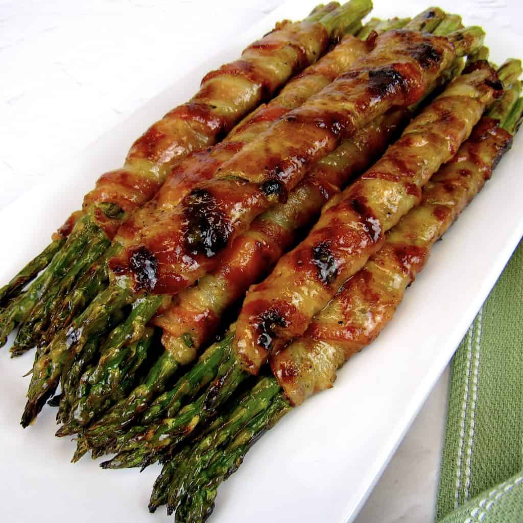 overhead view of Grilled Bacon Wrapped Asparagus on white plate