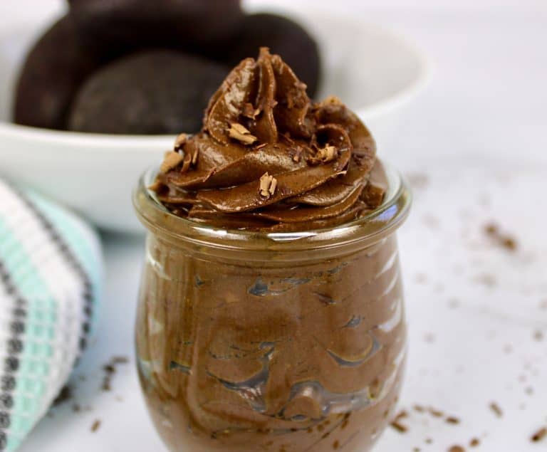 avocado chocolate mousse in glass jar with avocados in background