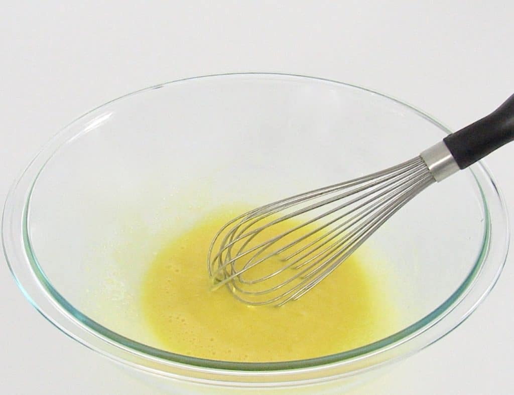 eggs and sweetener in glass bowl with whisk