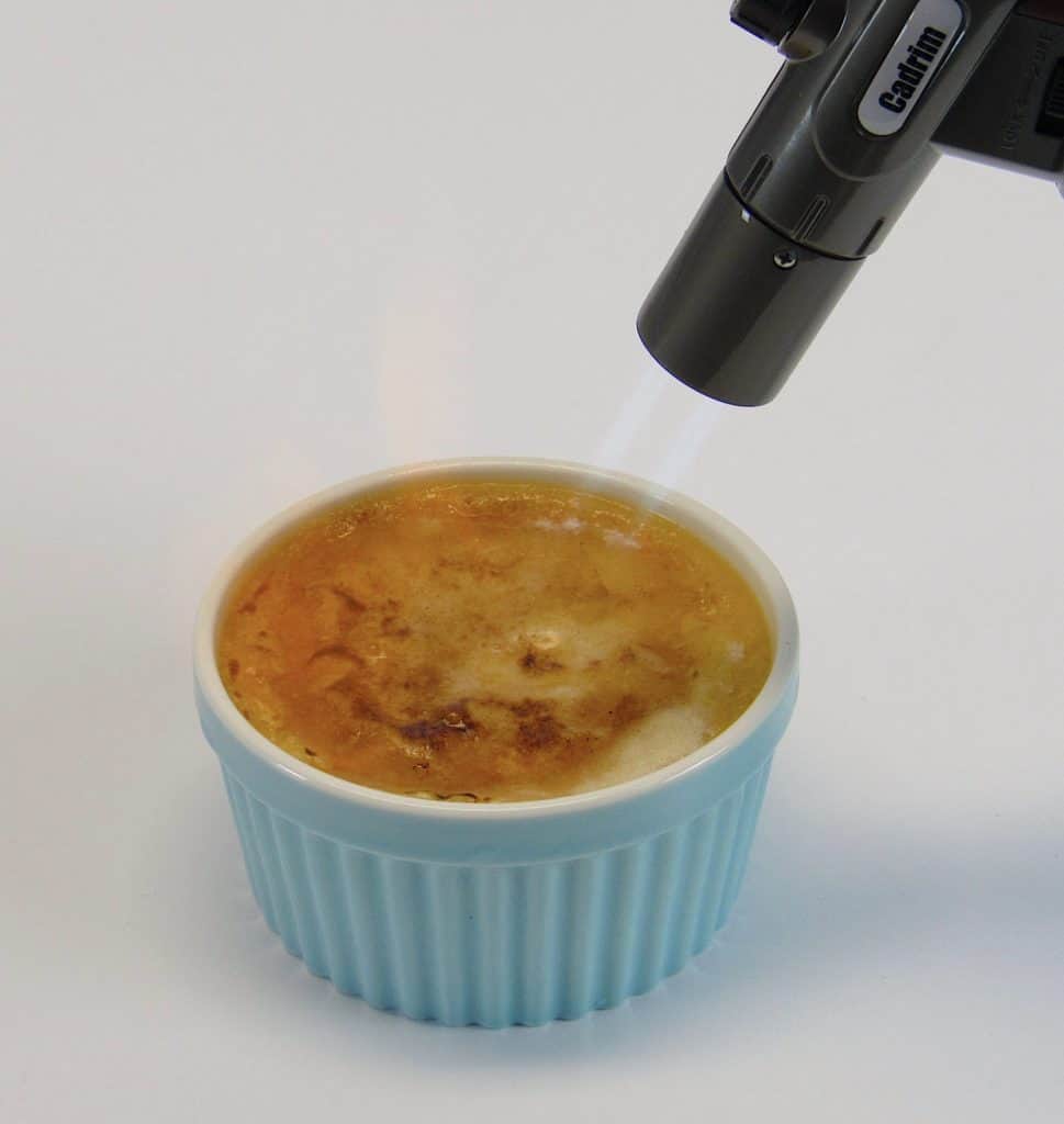 Keto Creme Brûlée with torch caramelizing the top