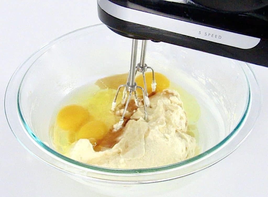 eggs with wet ingredients being mixed in glass bowl