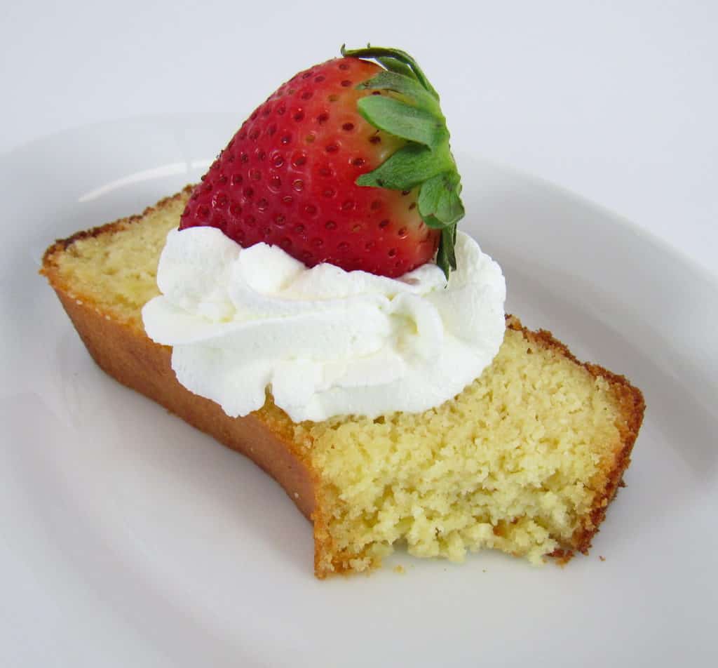 slice of pound cake with whip cream and a strawberry on top