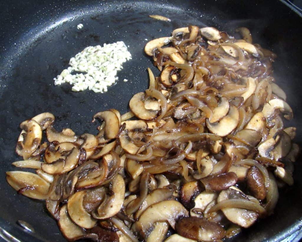 onions mushrooms and garlic cooking in skillet