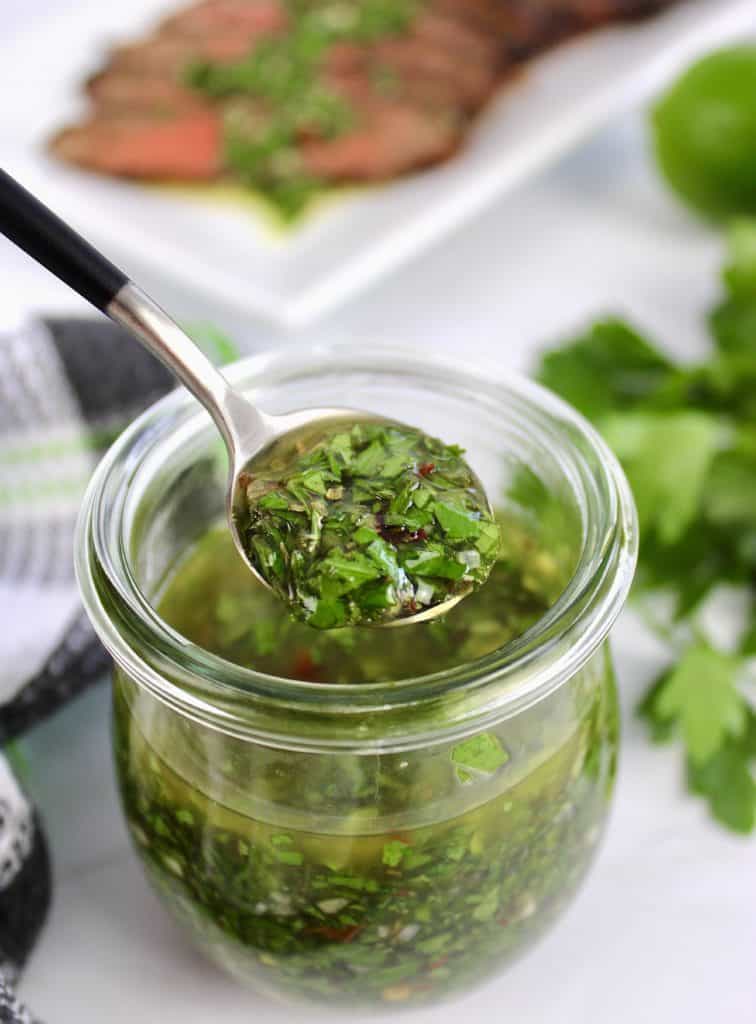 chimichurri sauce being spooned out of jar
