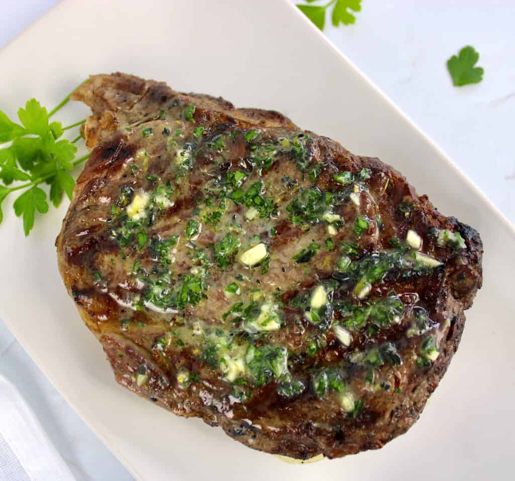 Grilled Steak with Garlic Herb Compound Butter melted all over the top