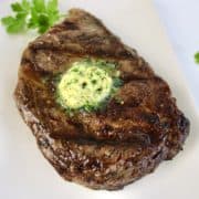 grilled ribeye steak with pad of compound butter on top