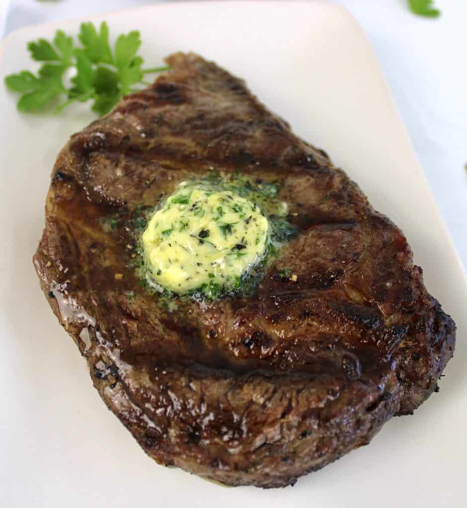 grilled ribeye steak with pad of compound butter on top