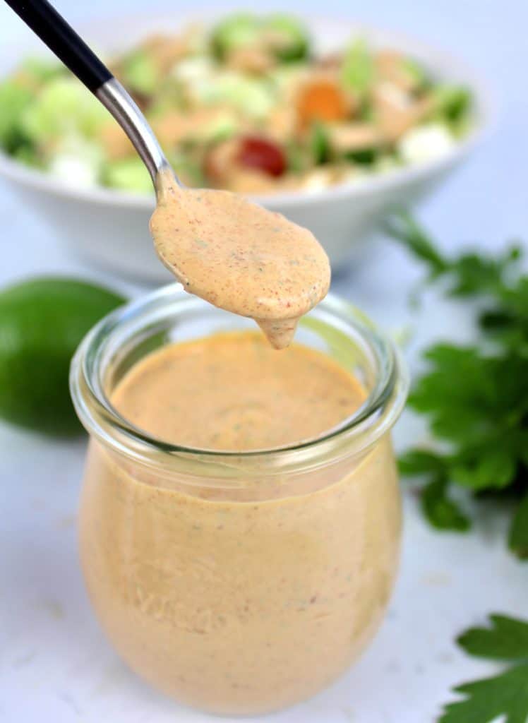 Keto Chipotle Ranch Dressing dripping off spoon into jar
