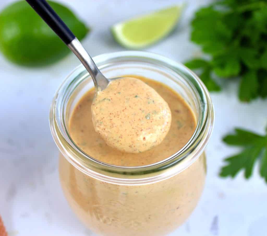 closeup of Keto Chipotle Ranch Dressing in glass jar on spoon