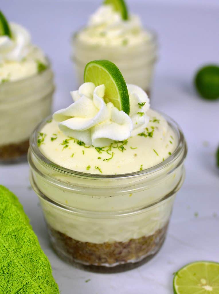 Keto No Bake Key Lime Cheesecake in glass jar with whip cream and lime on top