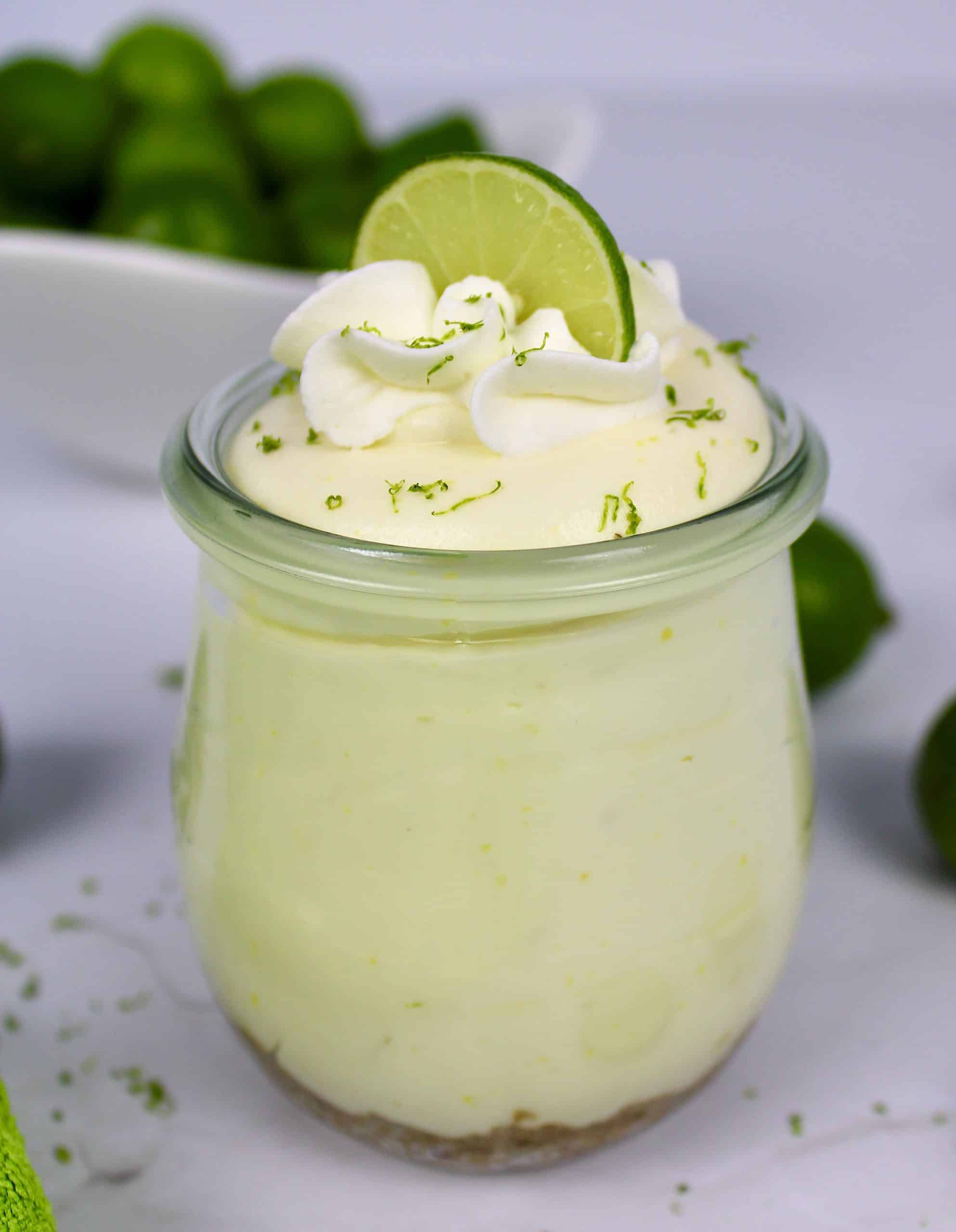 Keto No Bake Key Lime Cheesecake in glass jar with whip cream and lime on top
