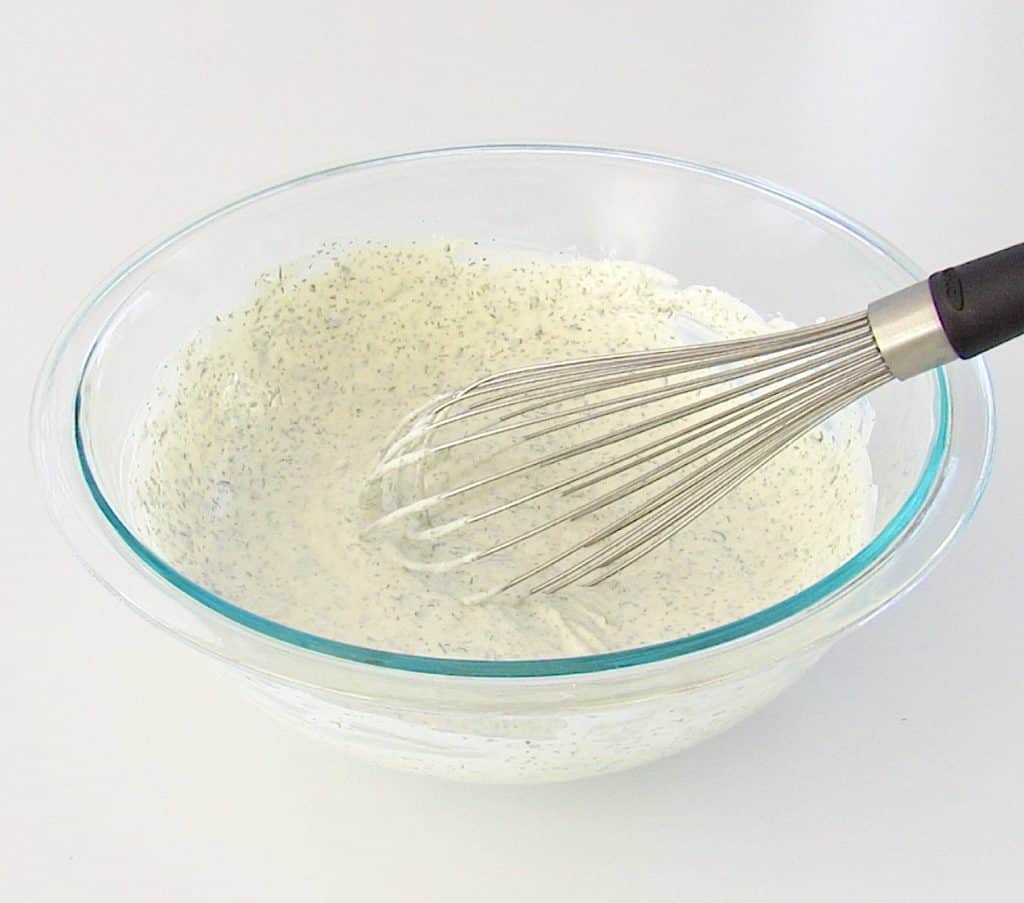 ingredients for ranch dressing in glass bowl with whisk