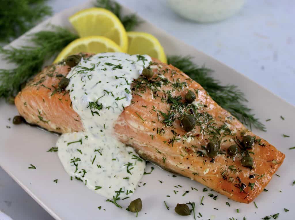 Baked Salmon with Creamy Dill Sauce on white plate