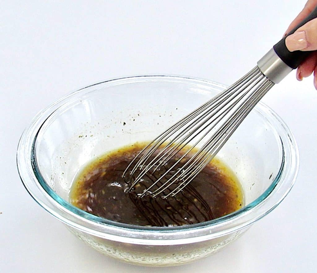 steak marinade ingredients in glass bowl with whisk
