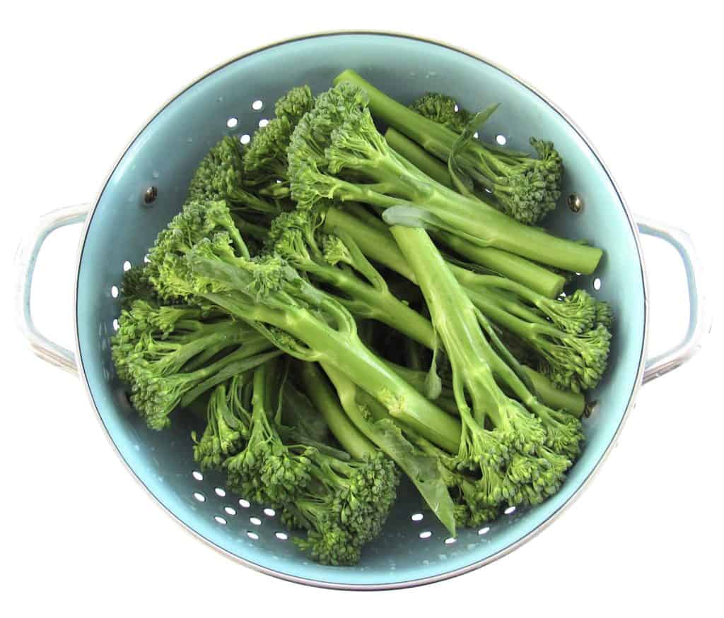 raw broccolini in collander