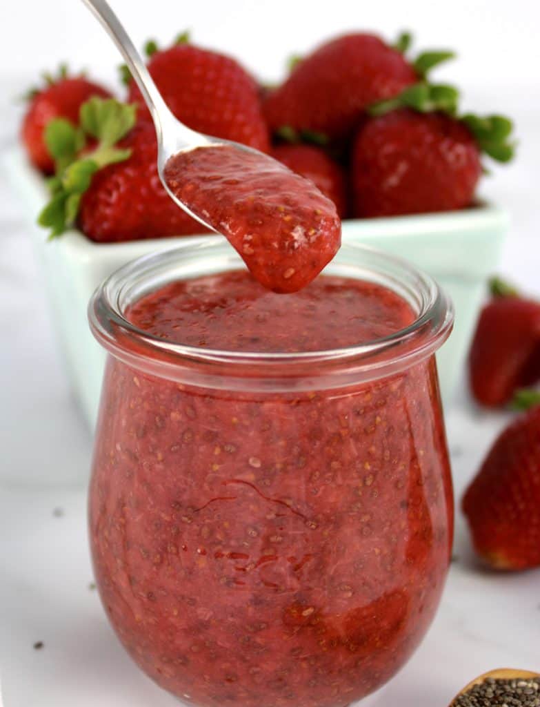 Keto Strawberry Chia Seed Jam in glass jar with spoon dripping