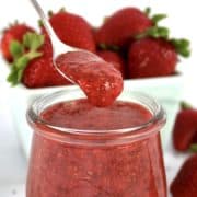 Keto Strawberry Chia Seed Jam in glass jar with spoon dripping